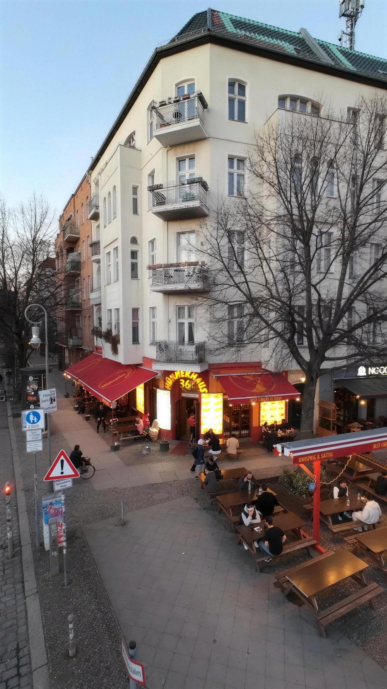Hühnerhaus 36 an der Straßenecke: Laden mit Markise und Außenplätzen